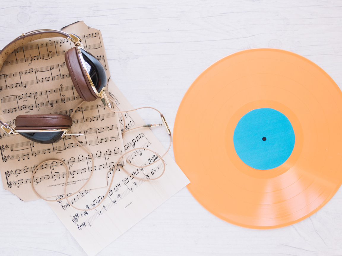 Наушники, ноты и виниловая пластинка на белом фоне