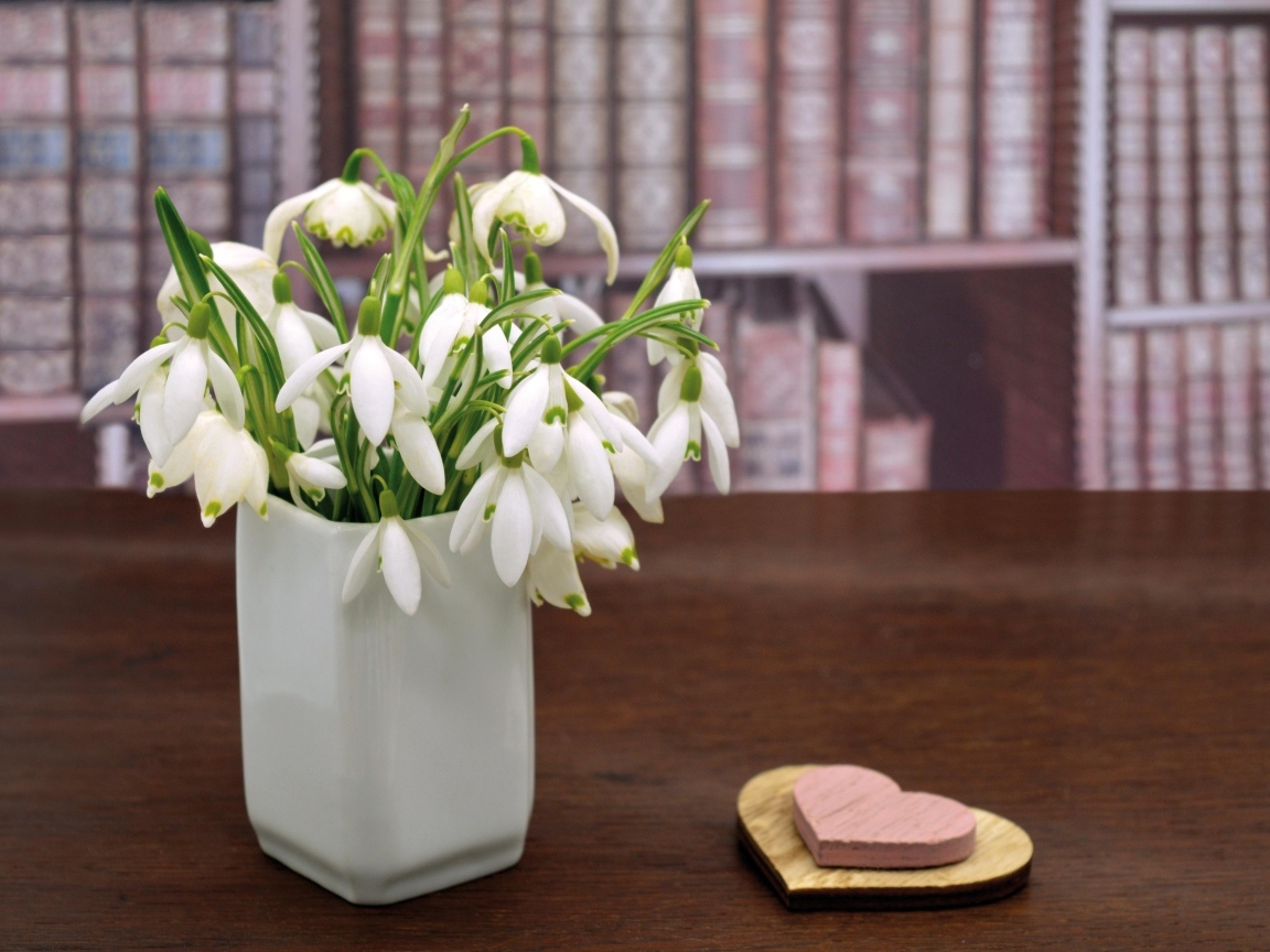Букет белых подснежников в вазе на столе с сердечками