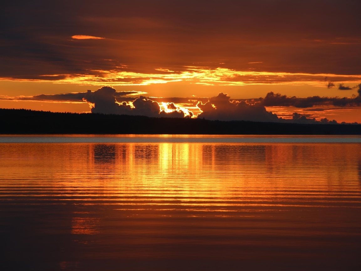 Красивый закат в облаках на горизонте у озера