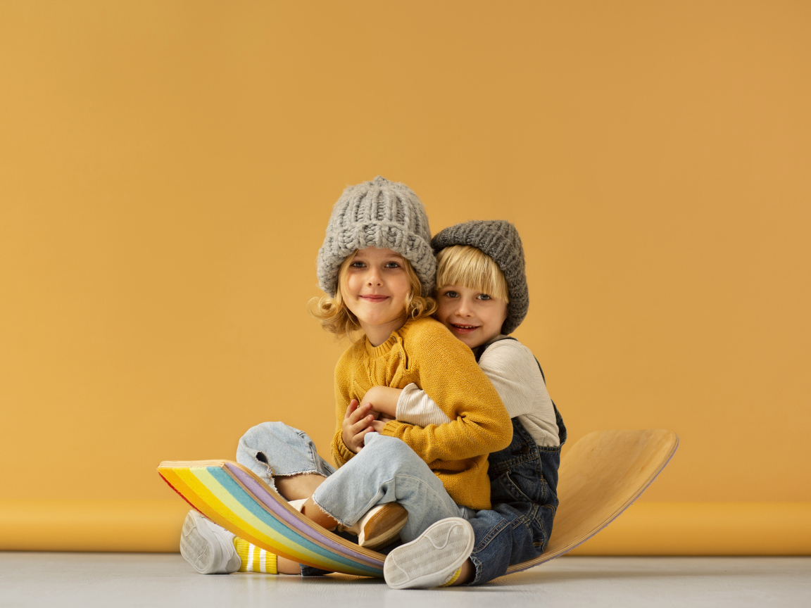 Счастливые брат и сестра в теплых шапках