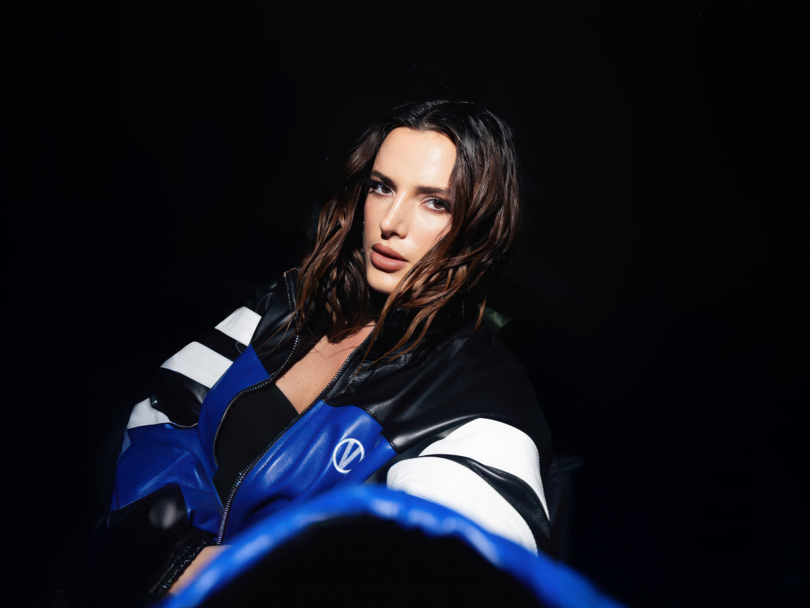 Актриса Белла Торн в кожаной куртке на черном фоне