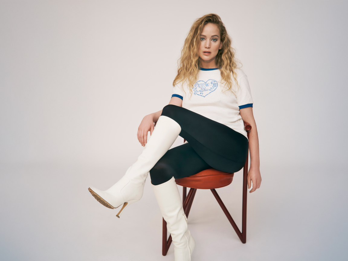 Актриса Дженнифер Лоуренс сидит на стуле на сером фоне