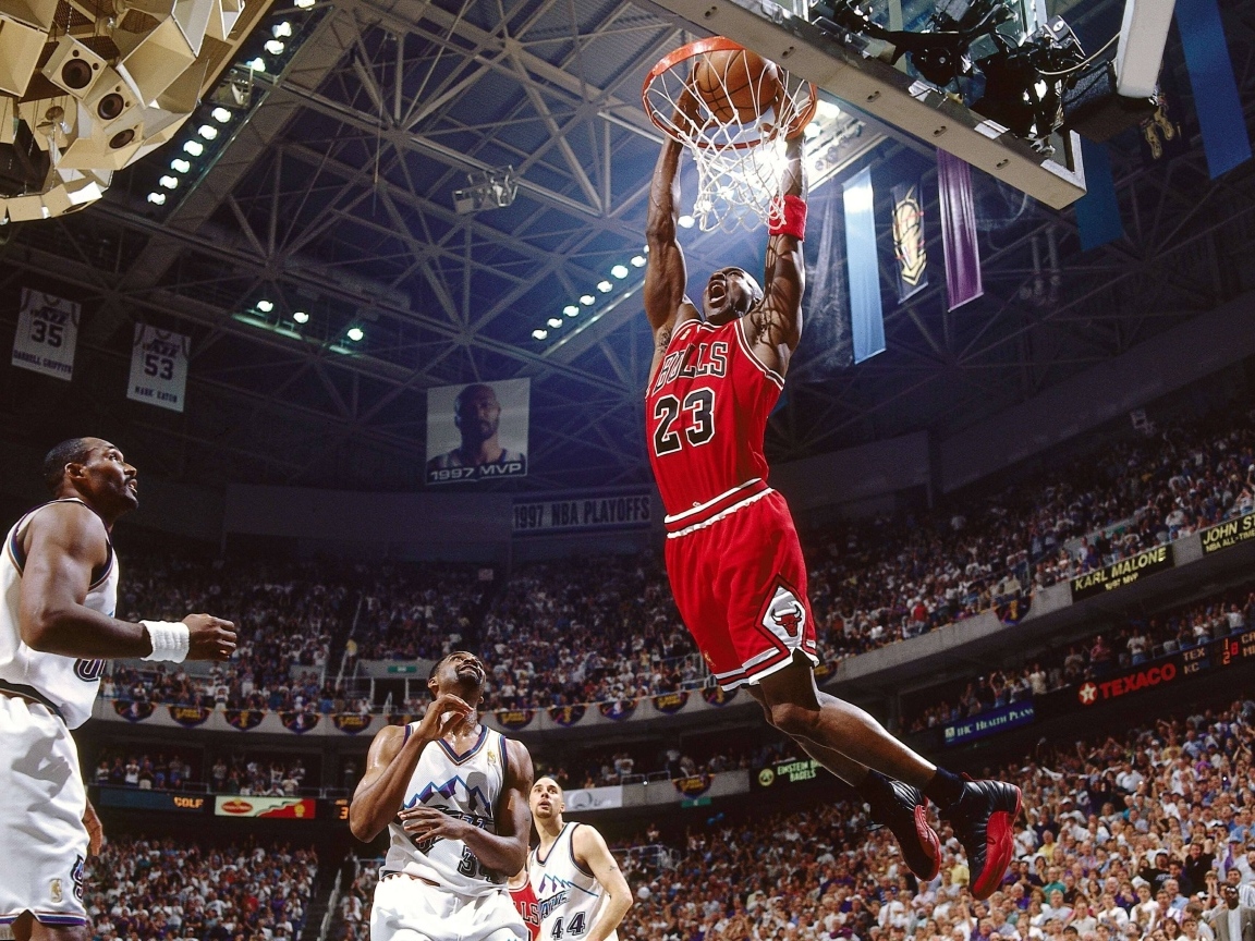 Баскетболист Майкл Джордан забрасывает мяч в кольцо
