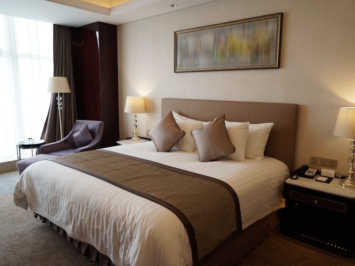 Большая кровать в комнате с картиной на стене