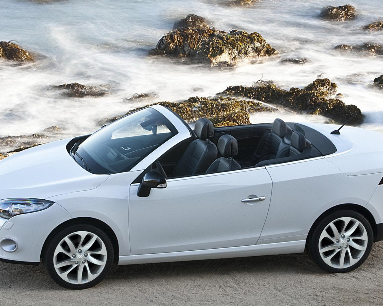 Рено Меган Купе Кабриолет двигаясь параллельно волнам