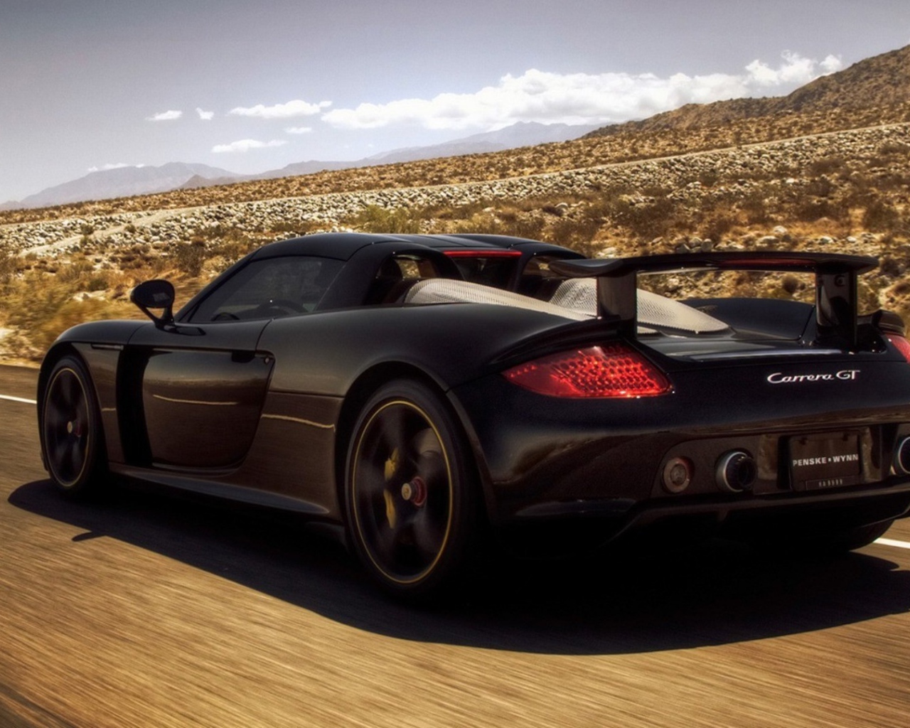 Черный автомобиль мчится по дороге