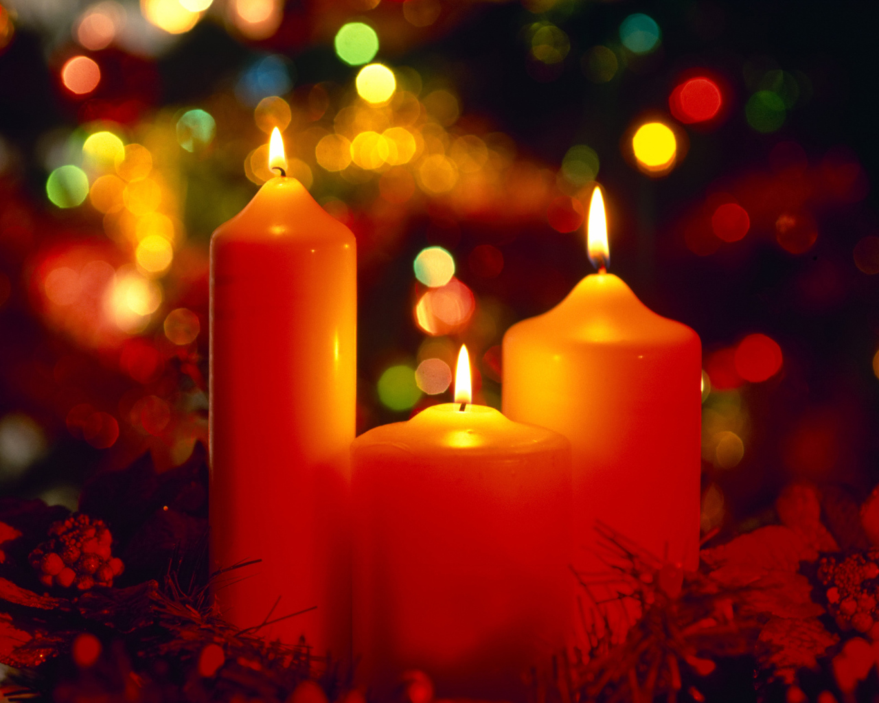 Горящие красные свечи на фоне гирлянды на рождество