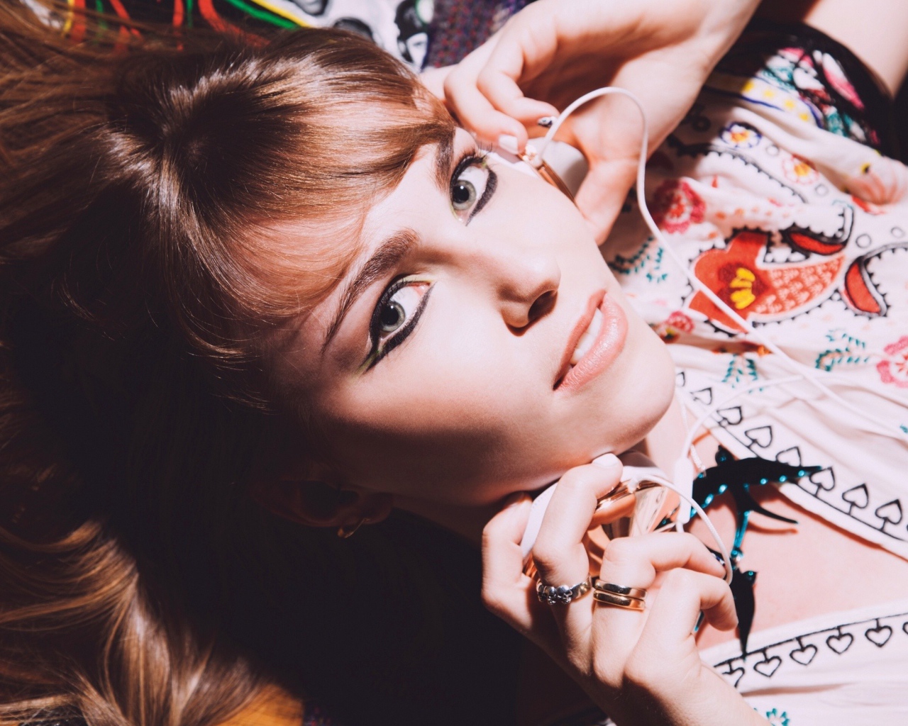 Девушка лежит с наушниками