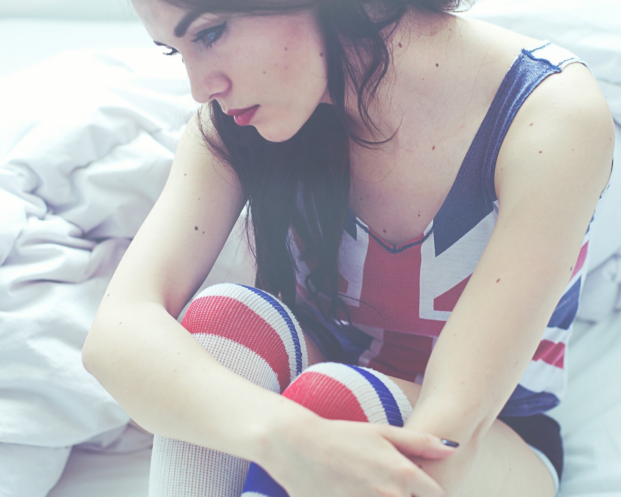 Девушка грустит на кровати