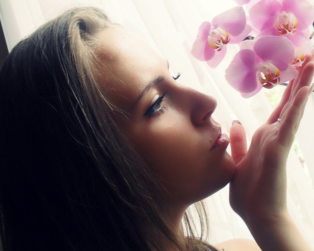 Девушка смотрит орхидею