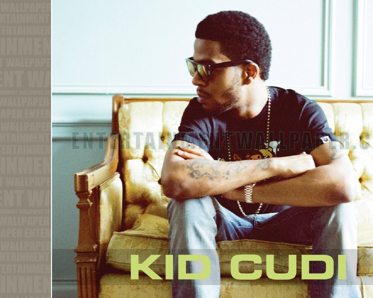 Kid Cudi сидит на желтом диване