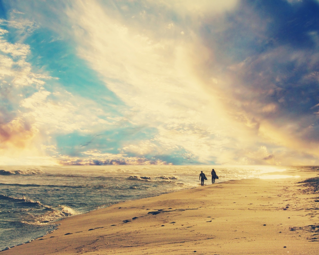 Двое идут по солнечному пляжу