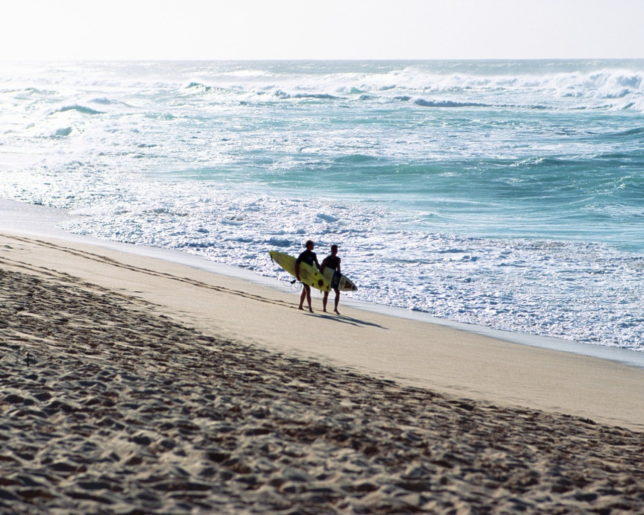 Два человека идут по пляжу
