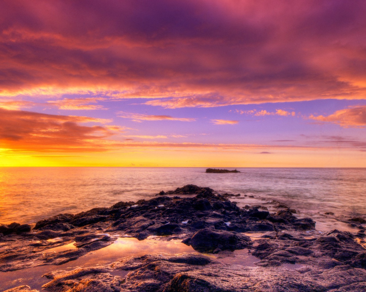 Разноцветный закат на каменистом побережье