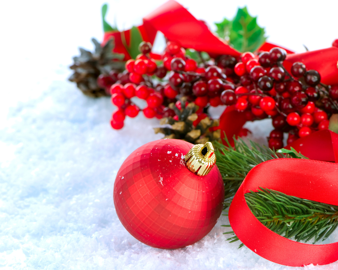Красные ёлочные украшения на снегу