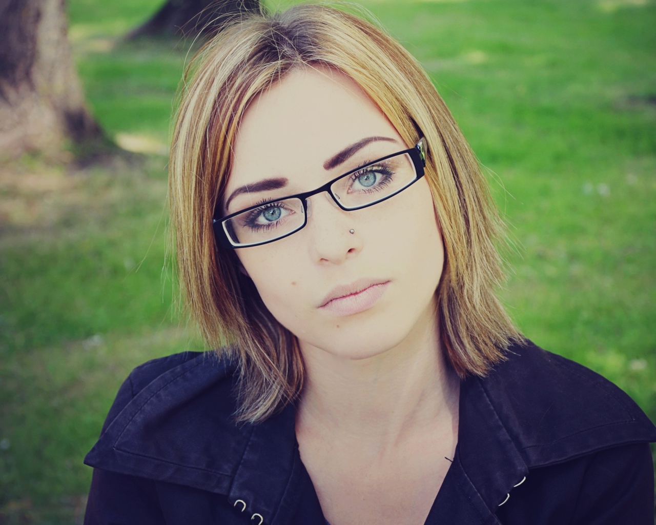 Blonde girl with piercings in the nose with glasses