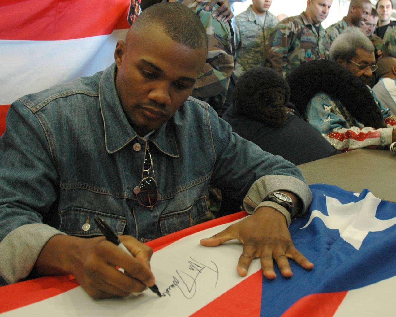 Боксер Феликс Тринидад подписывает флаг