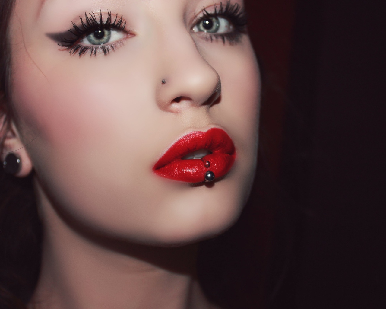 Девушка брюнетка с пирсингом в губе и носу