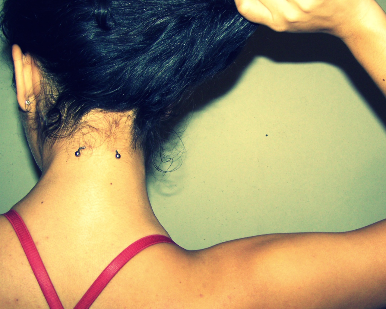 Девушка брюнетка с пирсингом в шее