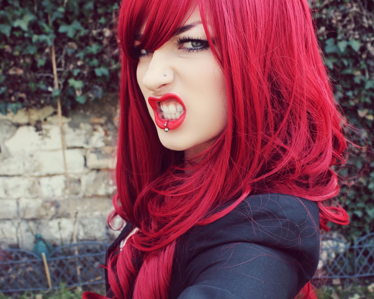 Девушка с красными волосам и пирсингом в носу и губе