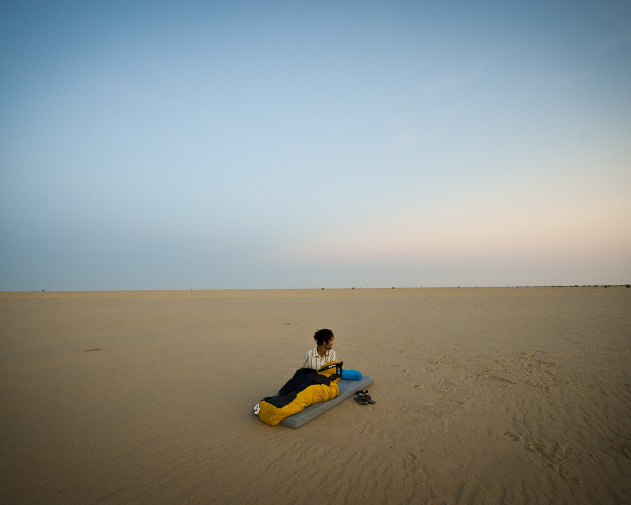 Мужчина на матрасе на пляже