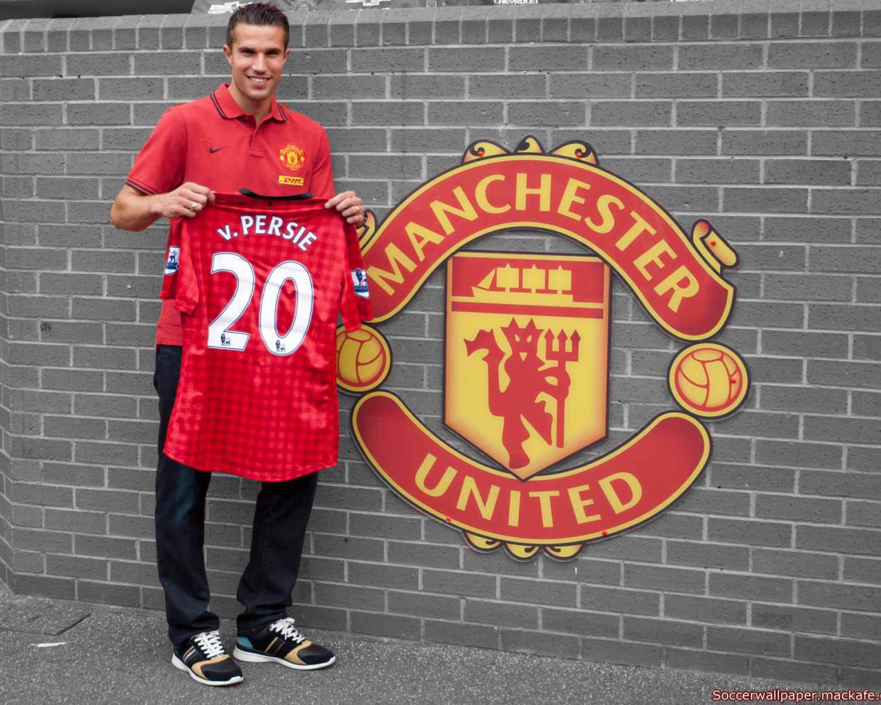 Нападавший из Манчестер Юнайтед Робин ван Перси держа собственную футболку