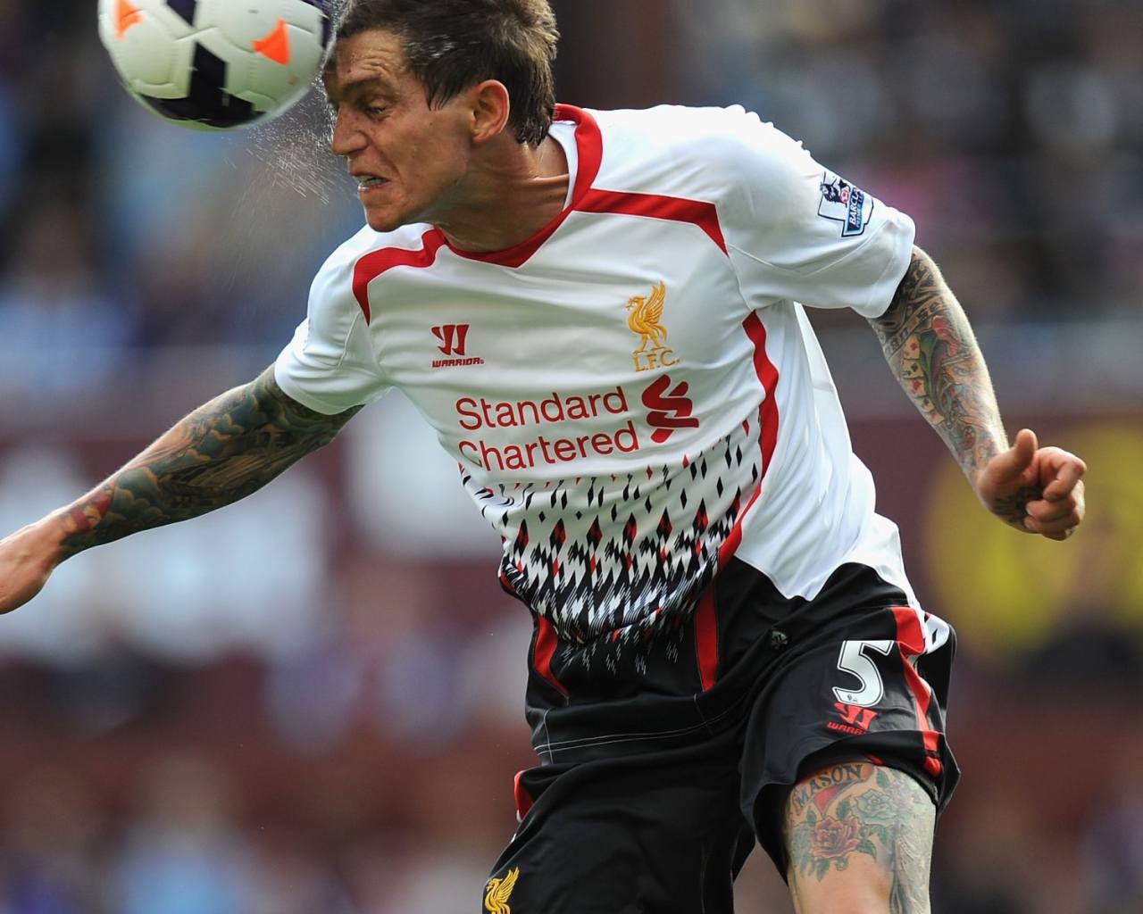 The player of Liverpool Daniel Agger is hitting a ball