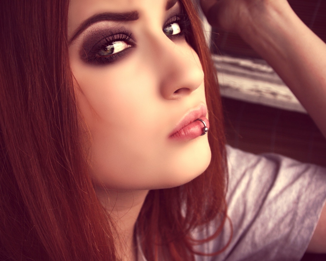 Молодая девушка шатенка с пирсингом в губе