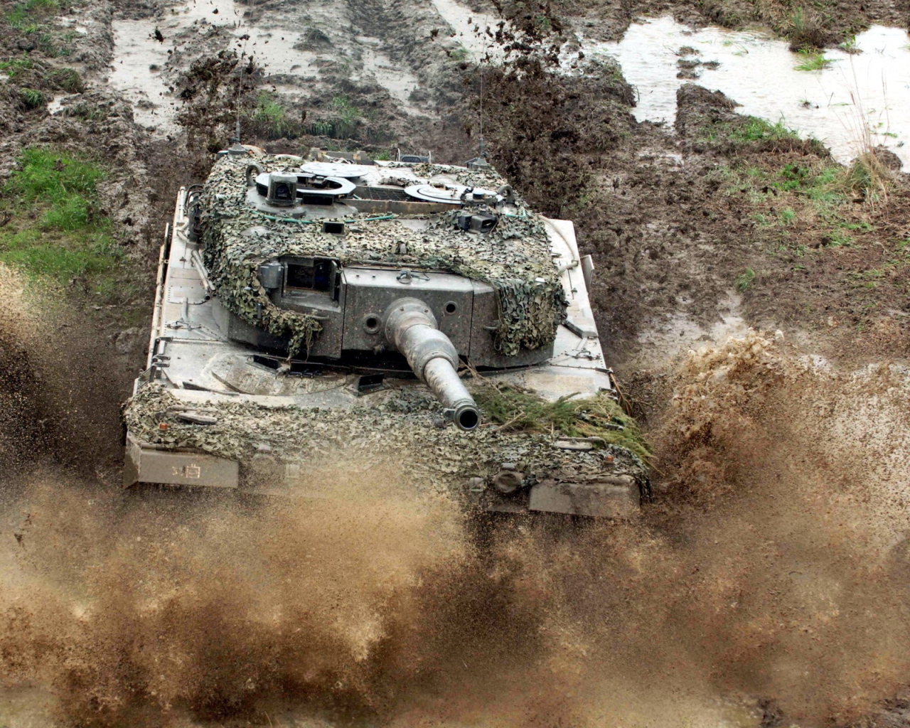 Танк в маскировке едет по грязи
