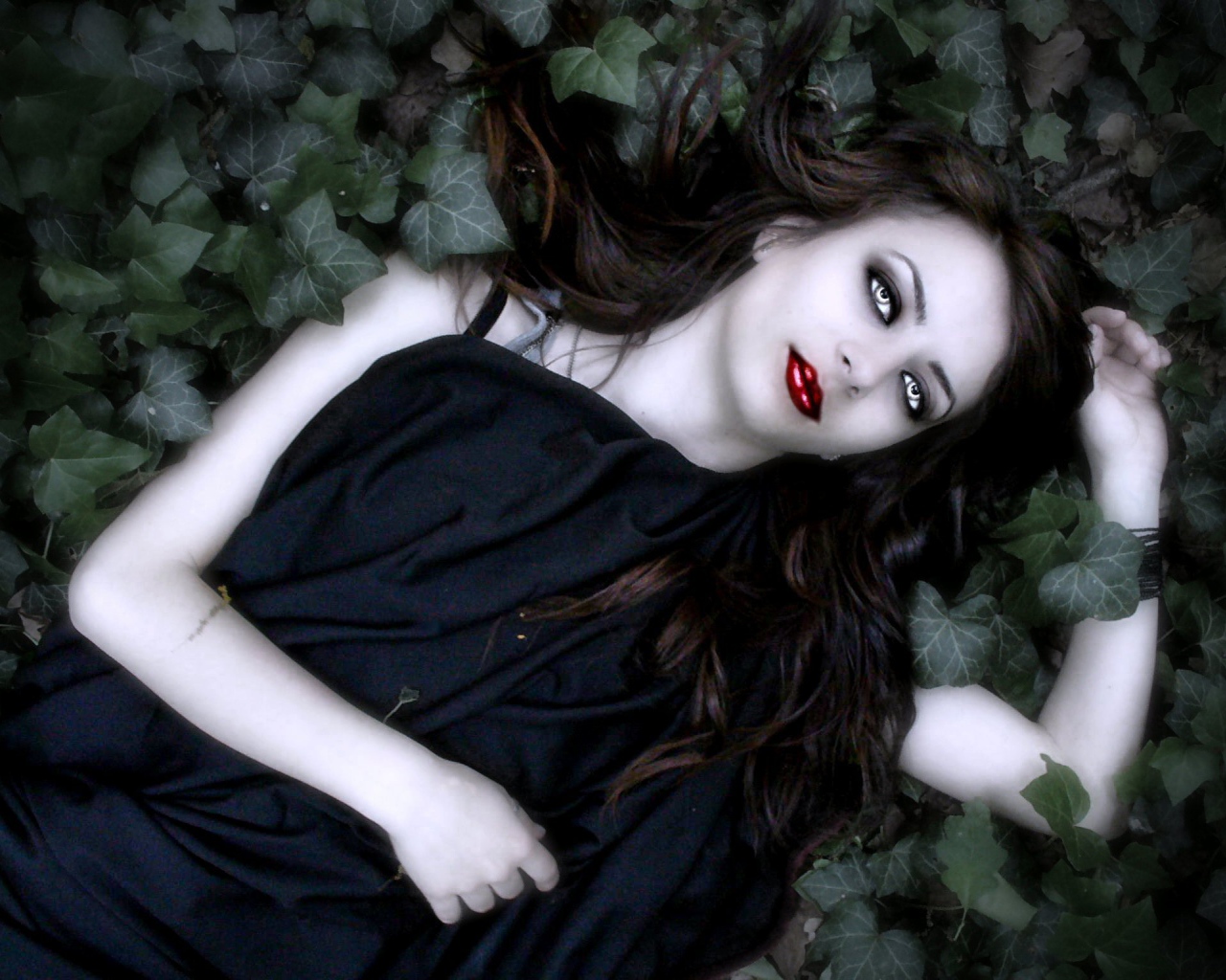 Девушка вампир лежит в листьях