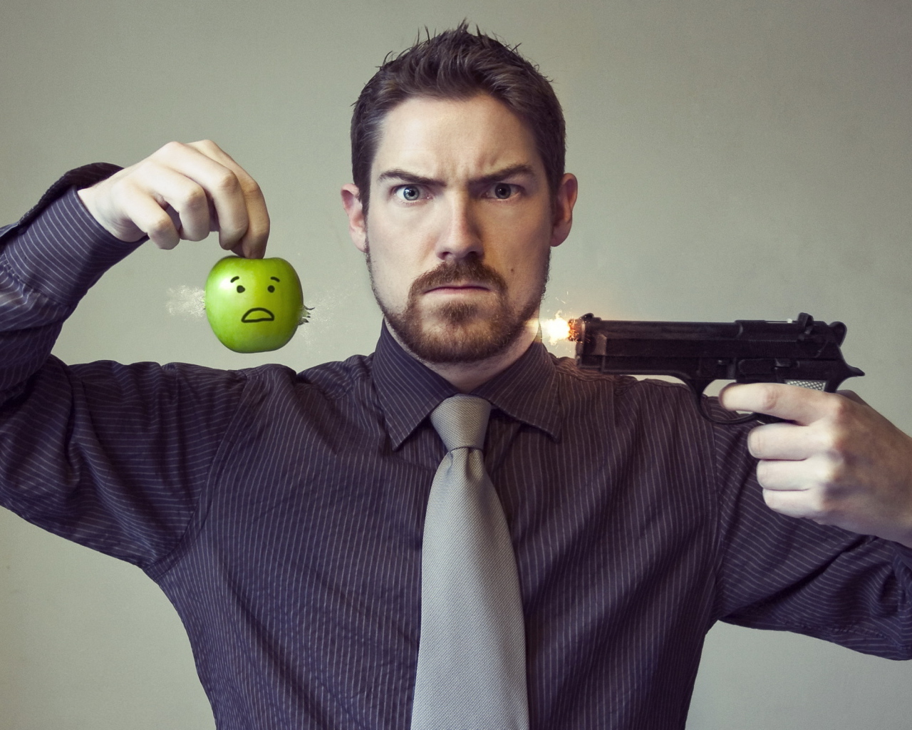 Мужчина стреляет в яблоко