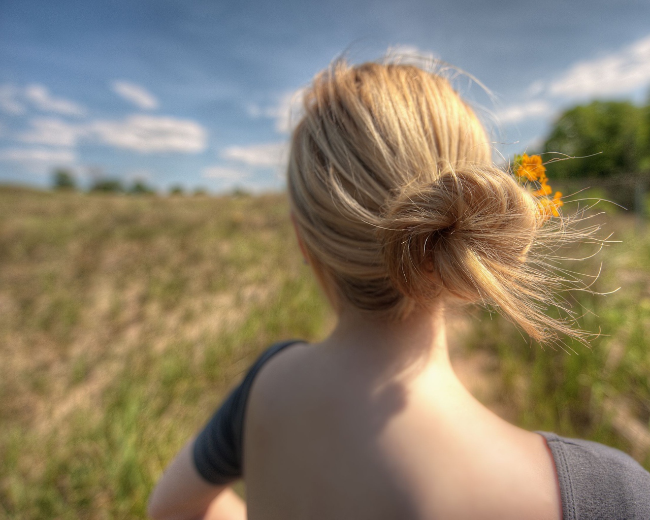Девушка с цветами в волосах в поле