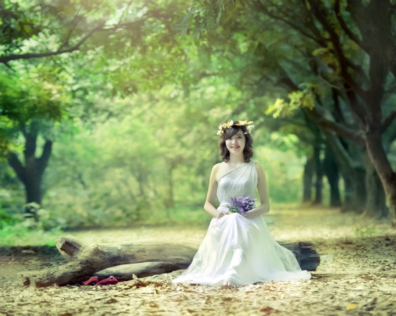 Девушка сидит на бревне