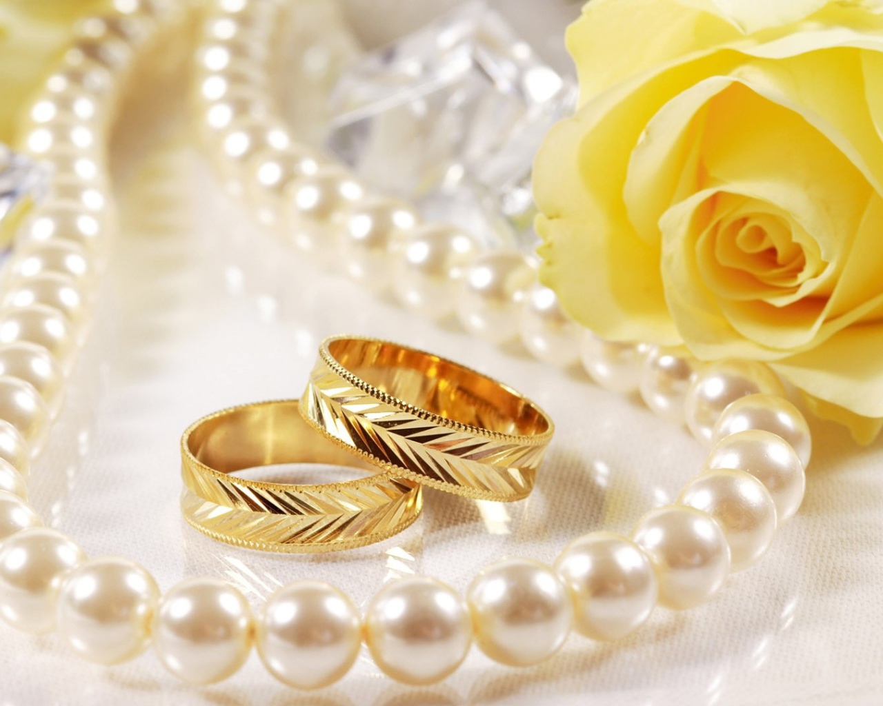 Свадебные кольца и жёлтая роза