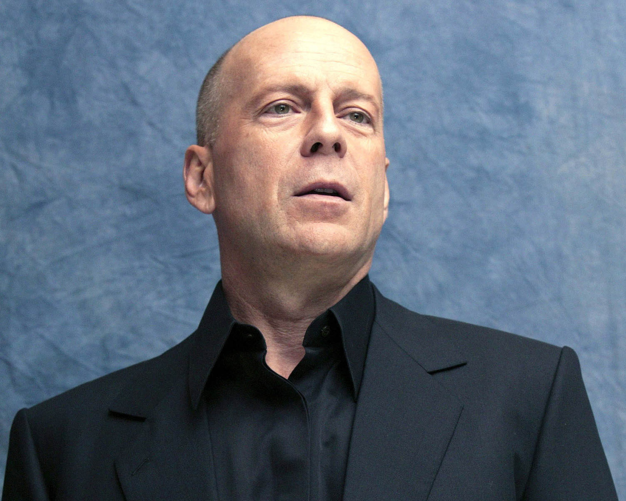 Известный актер Брюс Уиллис на синем фоне