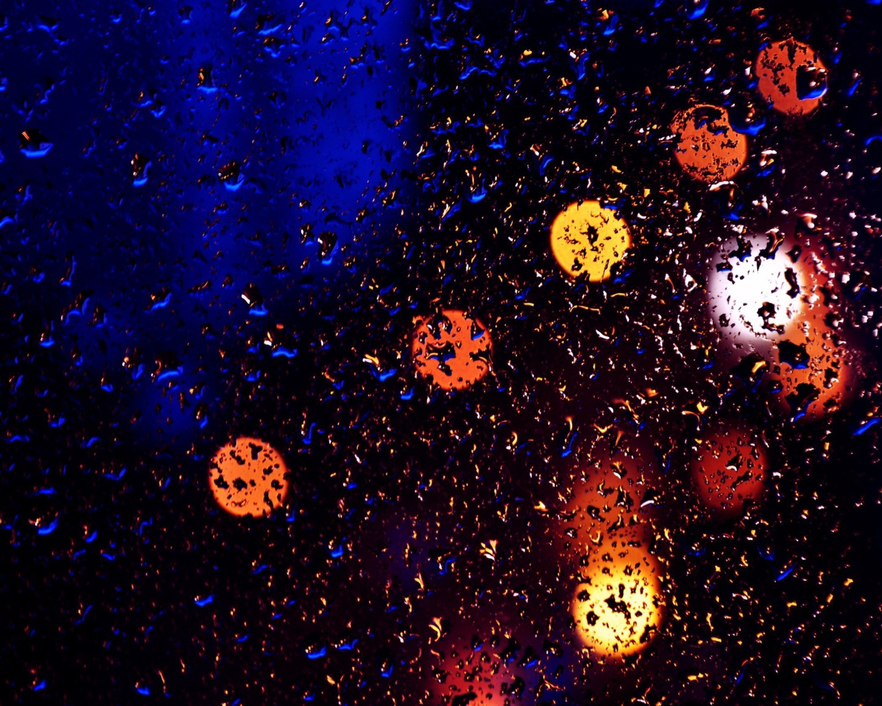 Свет фонарей через мокрое стекло