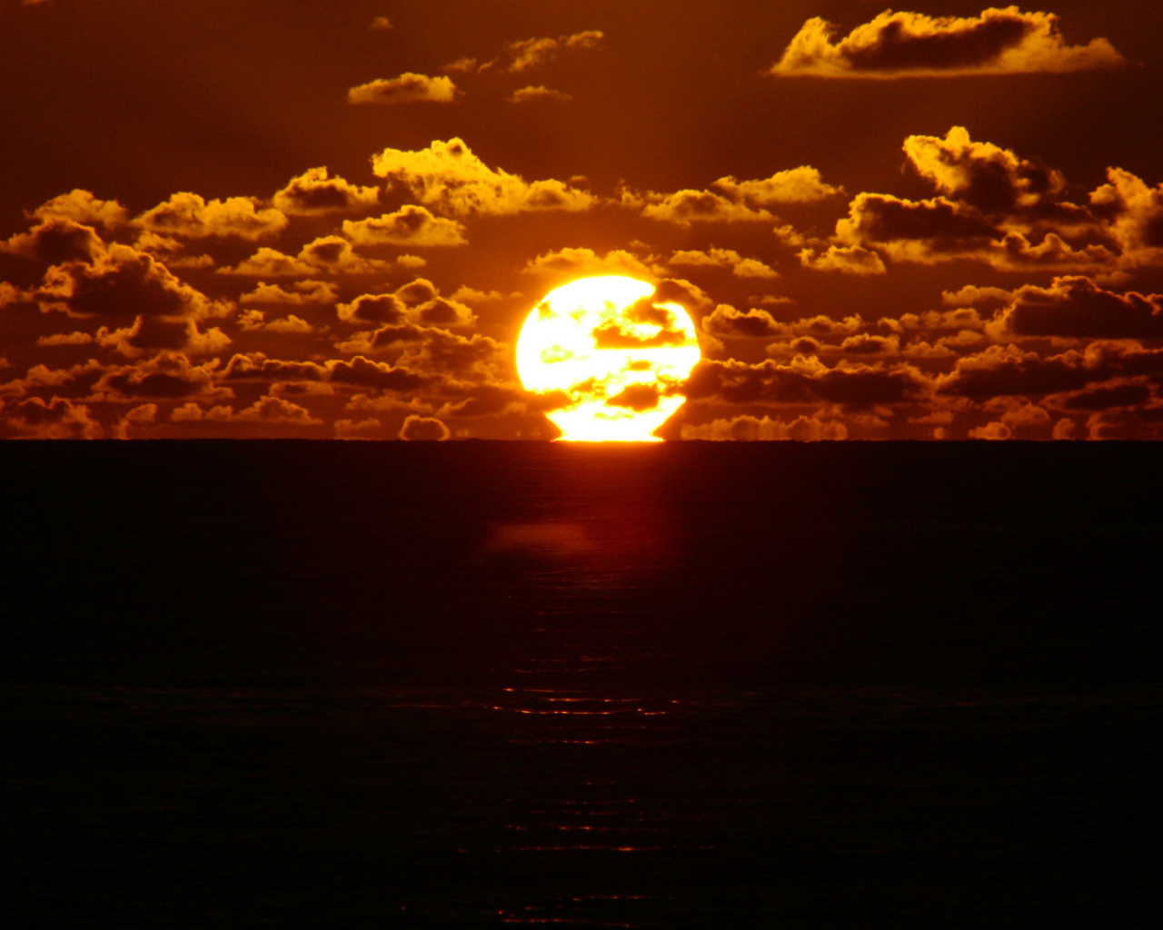Солнце между небом и морем