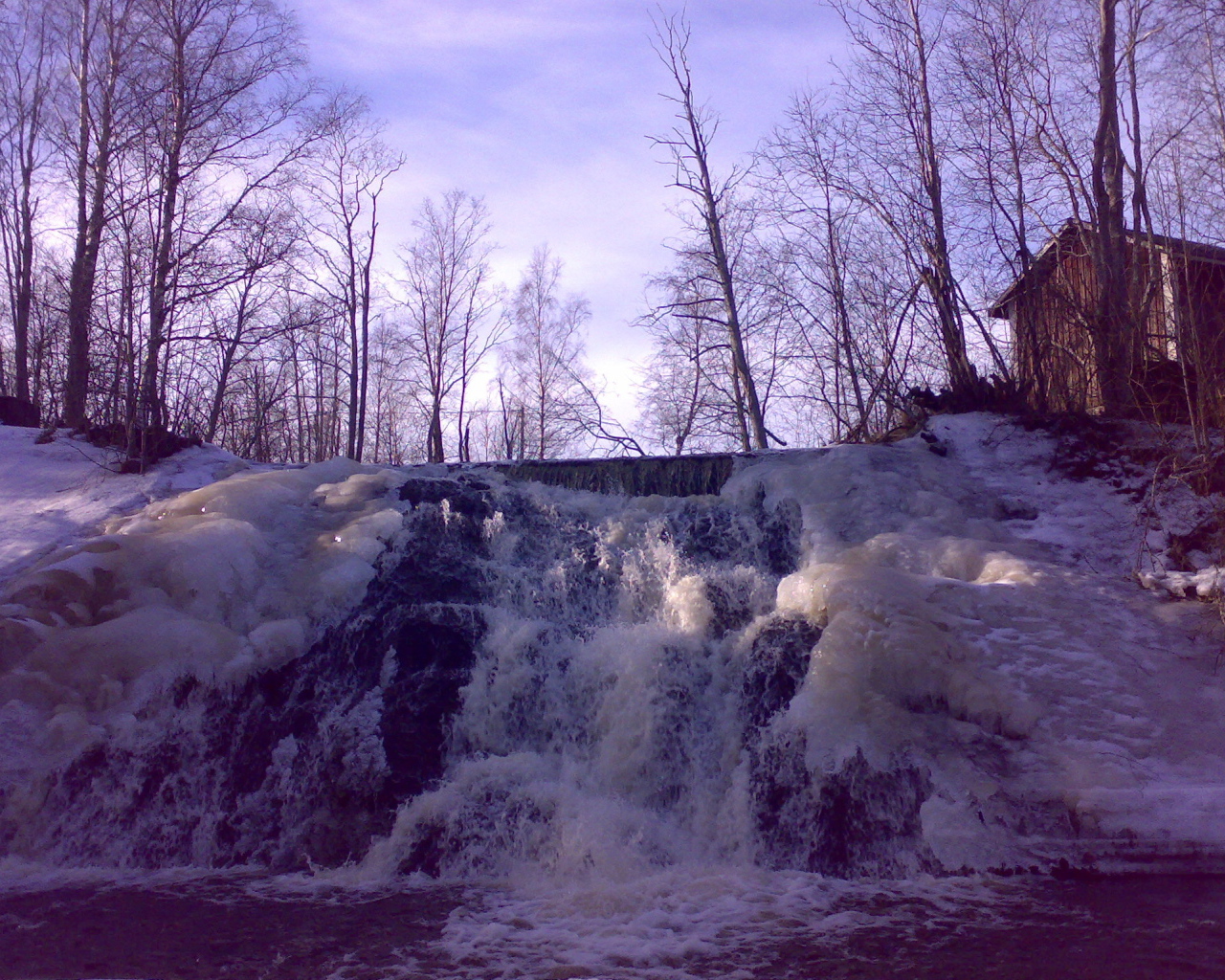 Замерзший водопад и хижина лесника