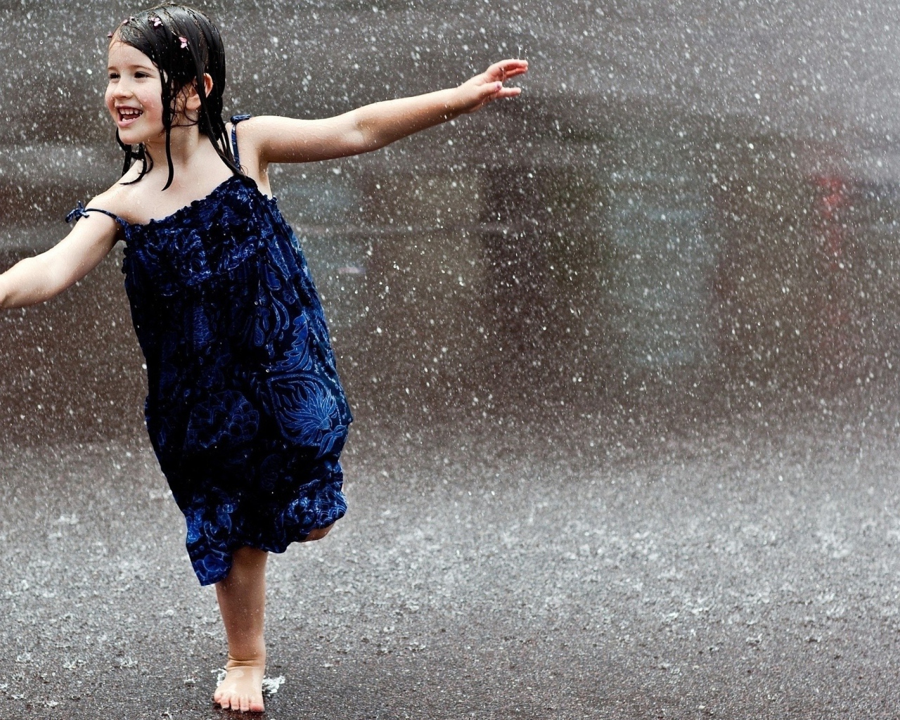 Счастливый ребенок бегает под дождем
