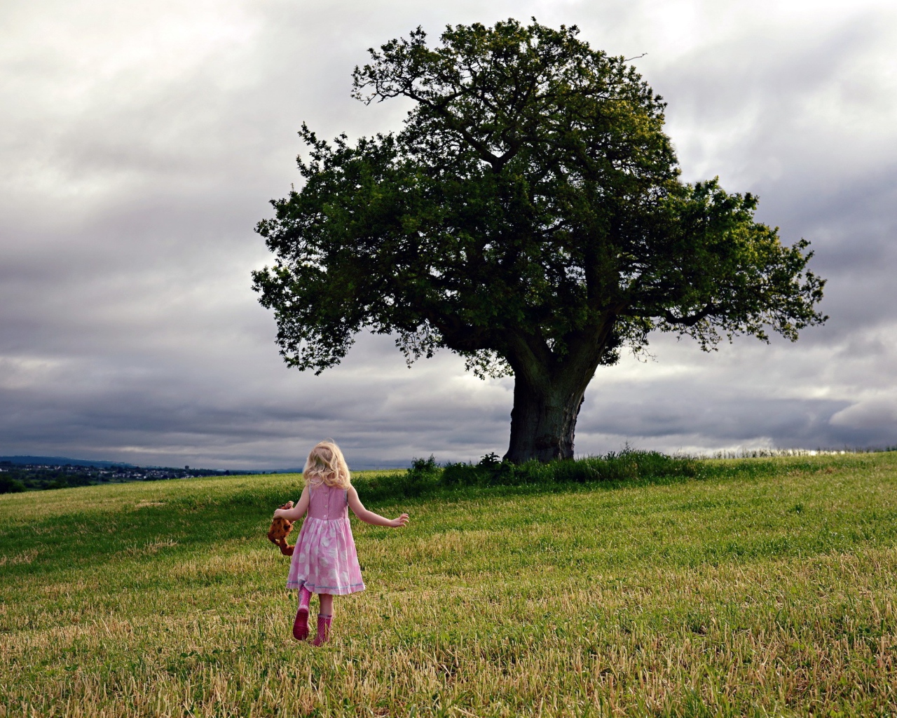 Маленькая девочка бежит к дереву