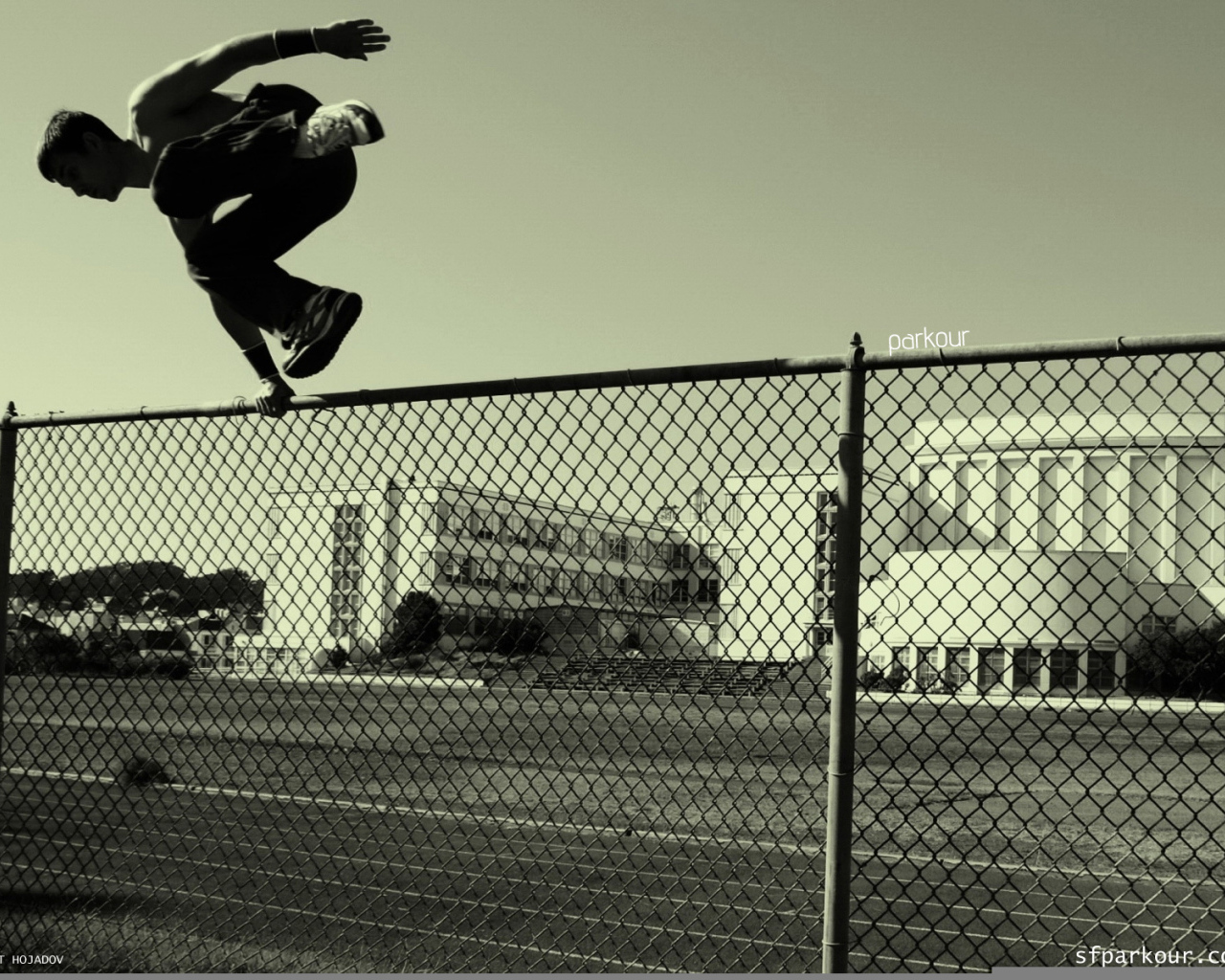 Паркурщик прыгает через забор