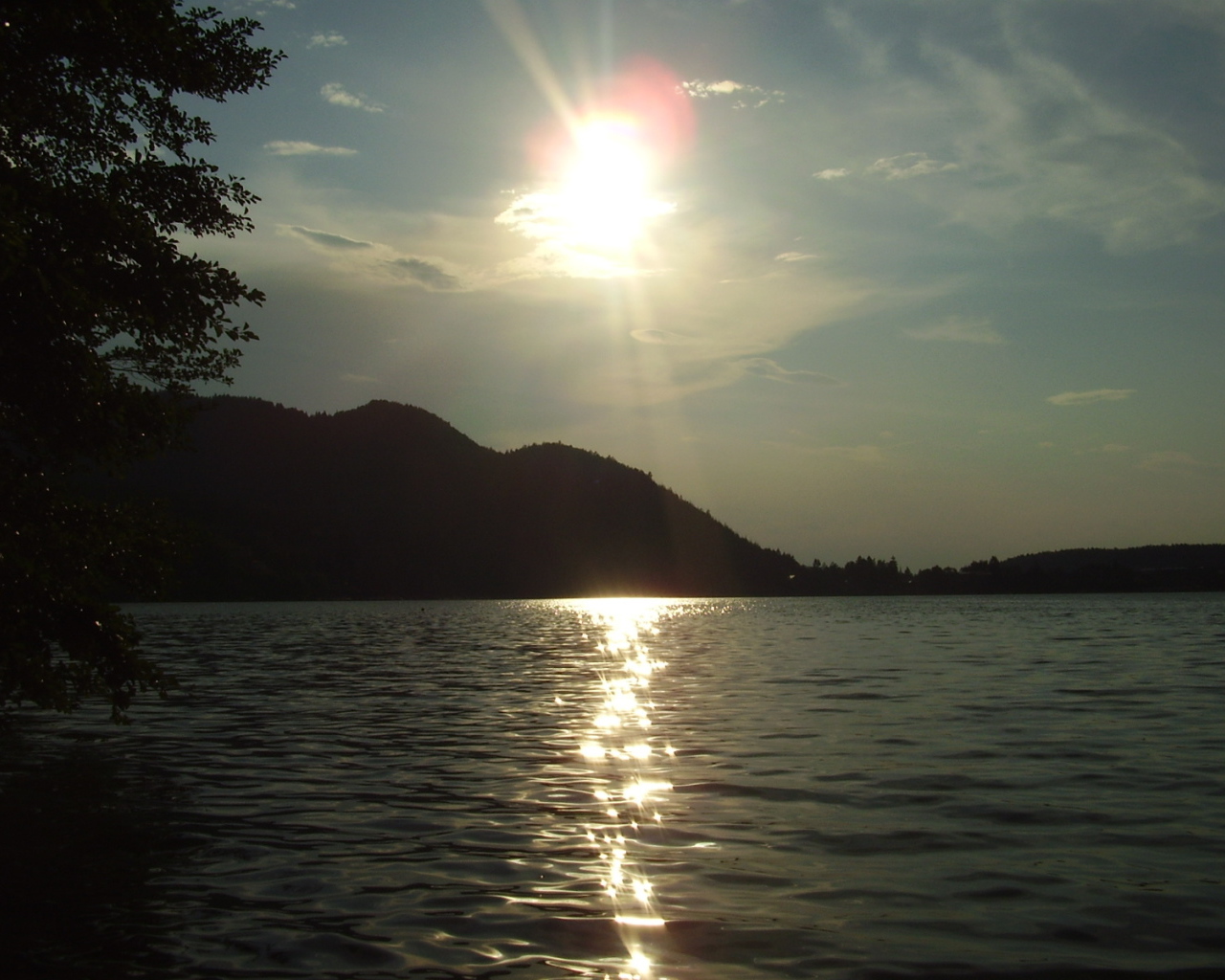 Солнце над водой озера Клопайнер Зее, Австрия