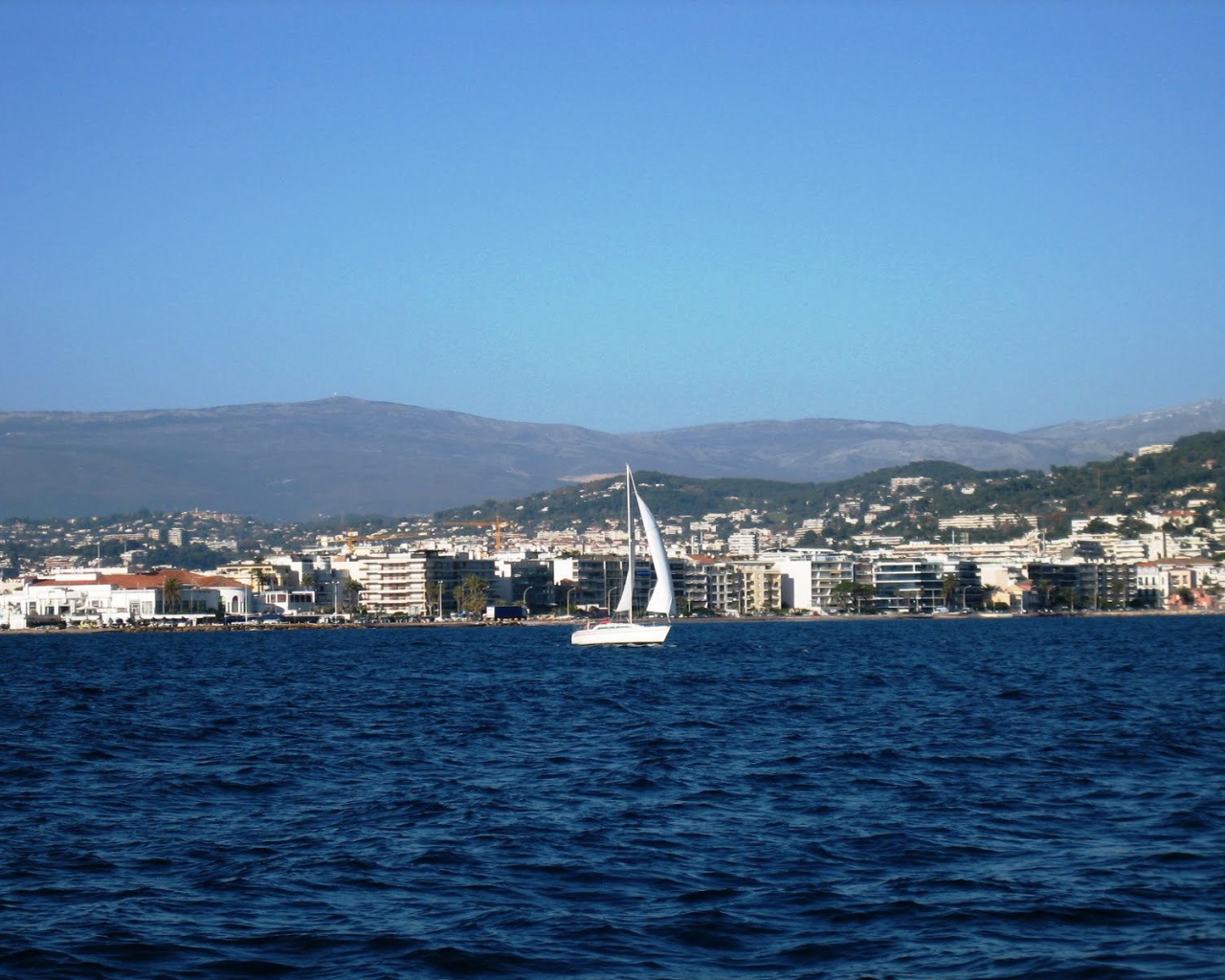 Яхта на фоне города на курорте Порт Де Фрежюс, Франция