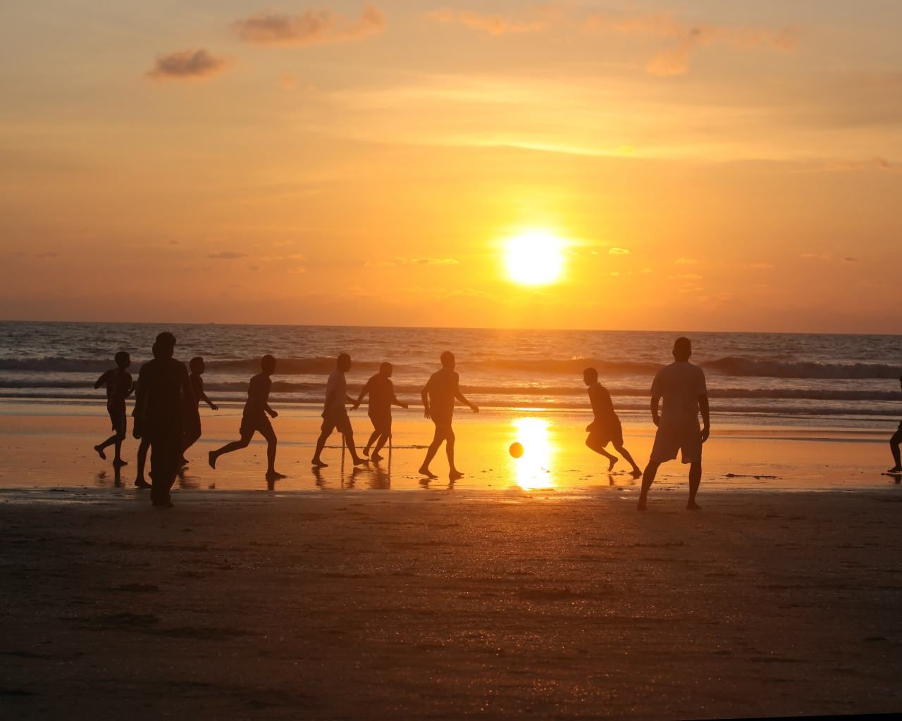 Парни играют в футбол на пляже в Гоа