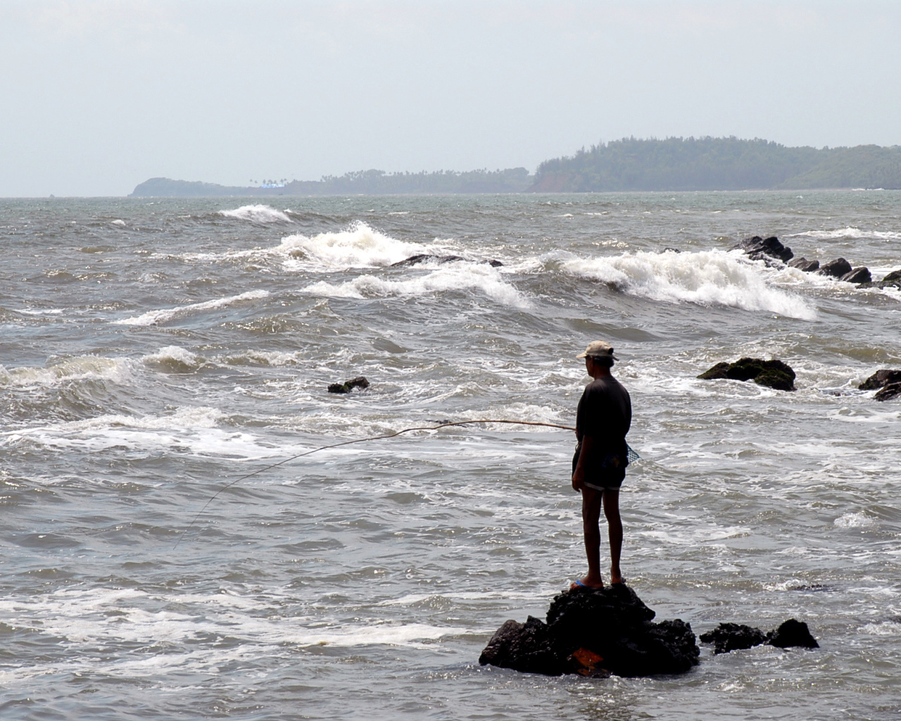 Мужчина ловит рыбу в Гоа