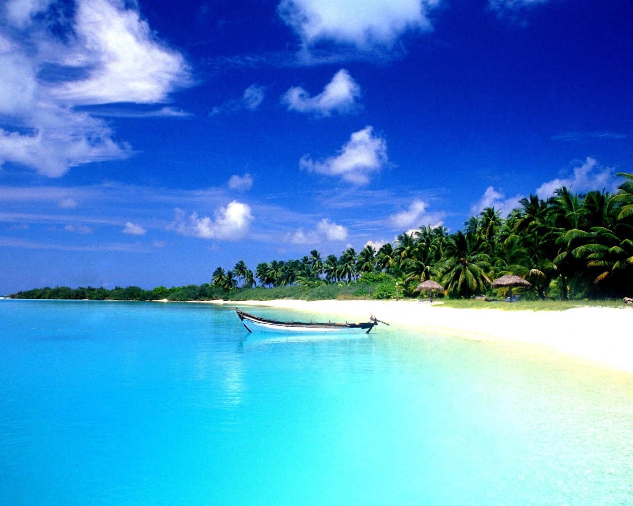 Белая лодка на лазурной воде в Гоа