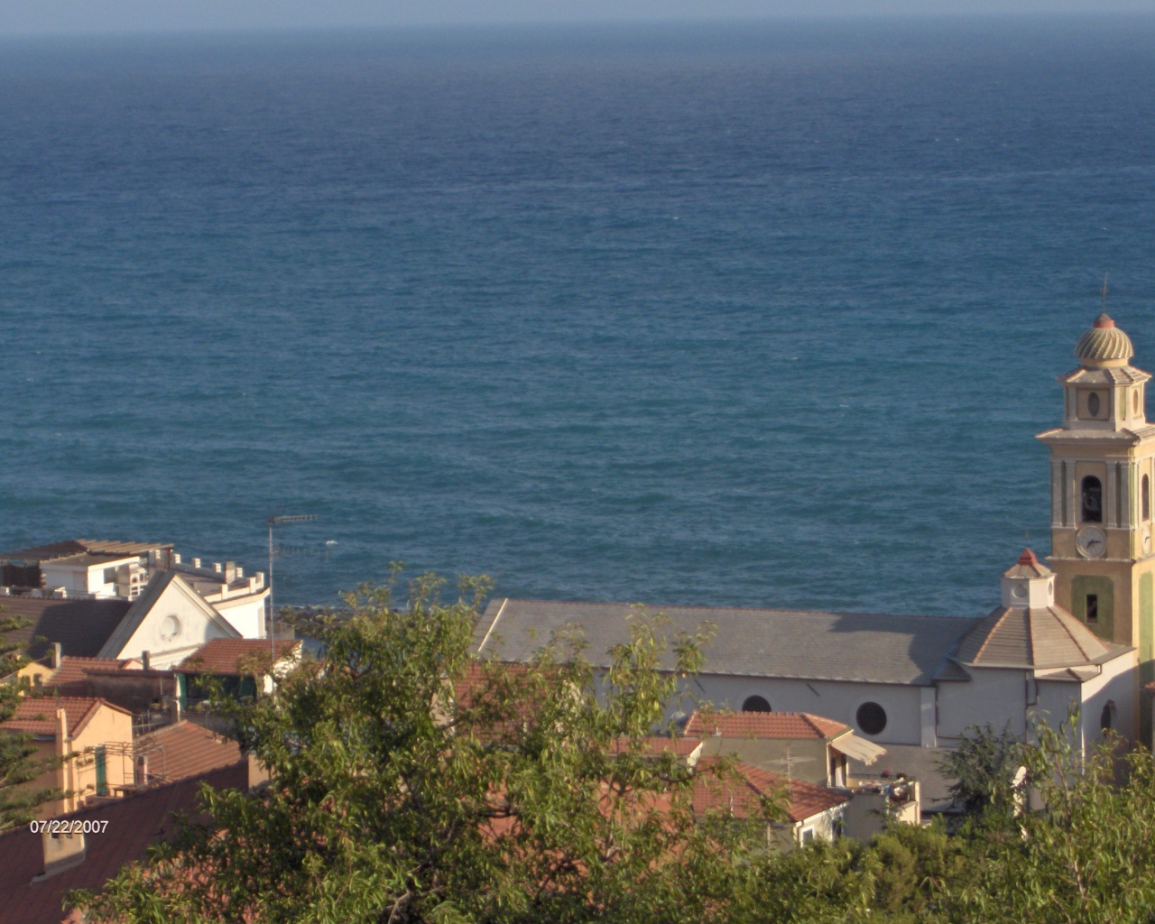 Башня с часами на фоне моря в Санто Стефано аль Маре, Италия