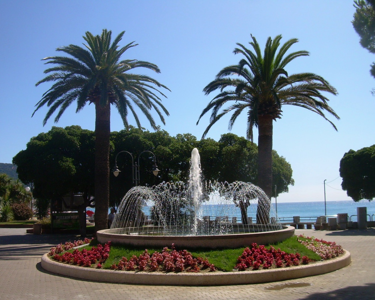 Фонтан на набережной на курорте в Пьетра Лигуре, Италия