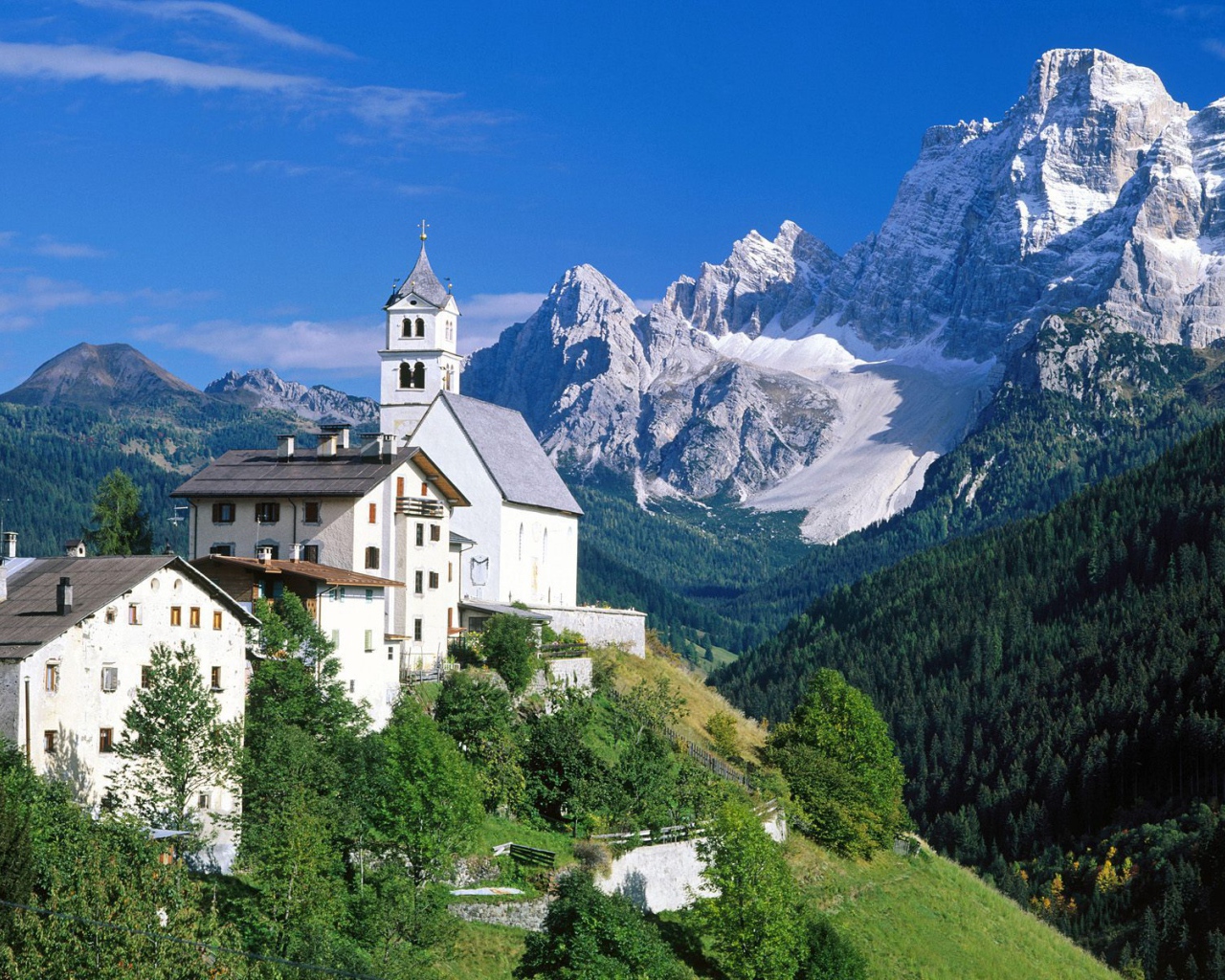 Дома на фоне гор на горнолыжном курорте Кортина д'Ампеццо, Италия