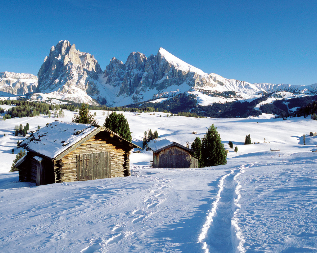 Дома на фоне гор на горнолыжном курорте Валь Гардена, Италия